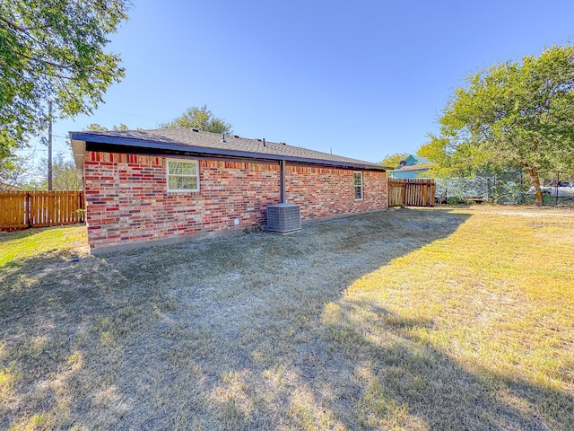 exterior space featuring central AC unit and a yard