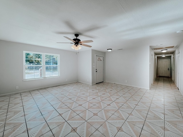 spare room with ceiling fan and light tile patterned floors