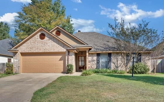 ranch-style house with a garage and a front lawn