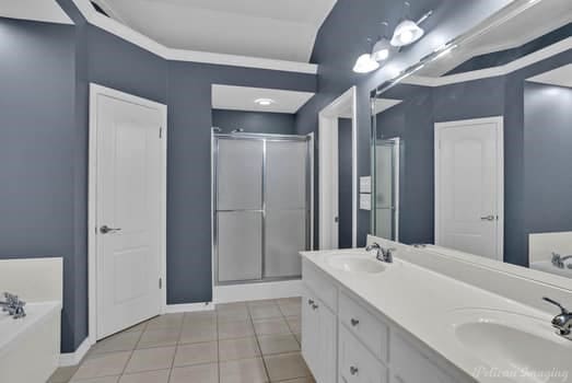 bathroom featuring vanity, shower with separate bathtub, and tile patterned flooring