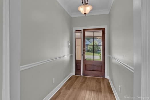 entryway with light hardwood / wood-style flooring and ornamental molding