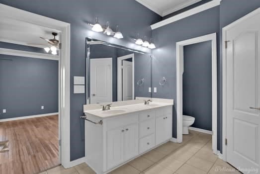 bathroom with vanity, toilet, tile patterned floors, and ceiling fan