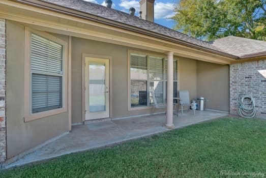 back of house with a yard and a patio