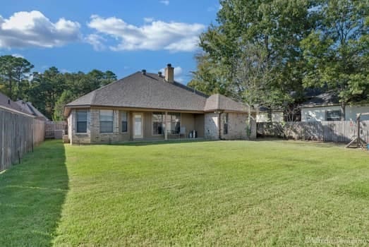 rear view of property featuring a lawn