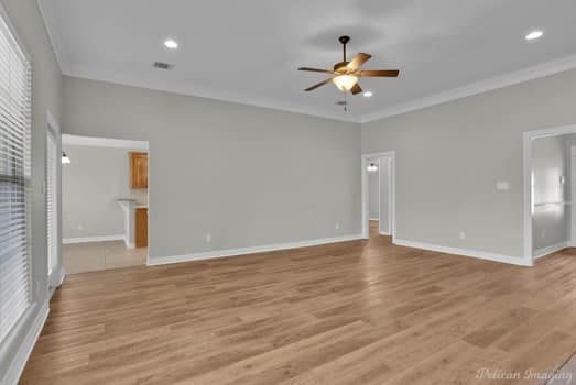 interior space featuring crown molding, light hardwood / wood-style flooring, and ceiling fan