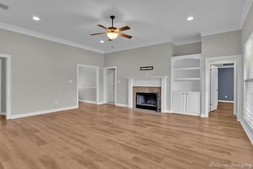 unfurnished living room with ornamental molding, light hardwood / wood-style flooring, and ceiling fan