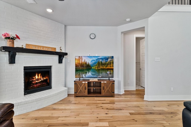 living area with recessed lighting, wood-type flooring, a fireplace, and baseboards