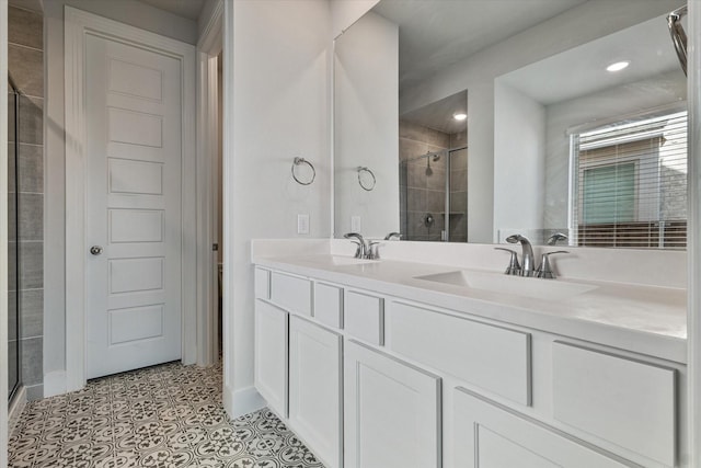 bathroom with double vanity, a stall shower, a sink, and tile patterned floors