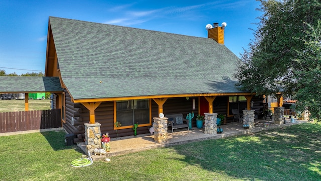 back of house with a patio and a lawn