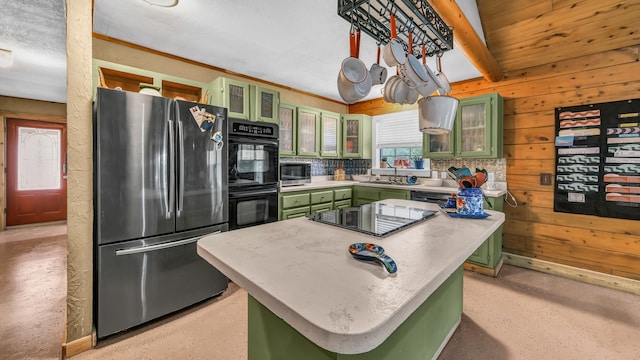 kitchen with backsplash, appliances with stainless steel finishes, green cabinets, wood walls, and a center island