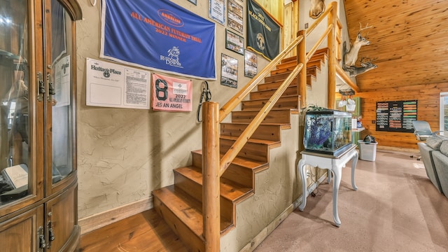 staircase with hardwood / wood-style flooring and wooden walls