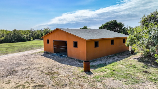 view of side of property featuring a lawn and an outbuilding