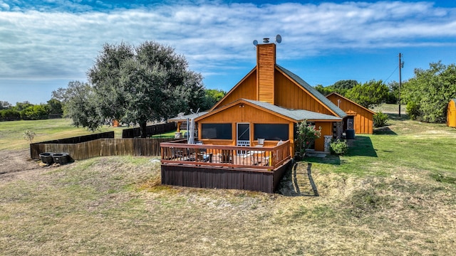 rear view of property featuring a wooden deck and a yard