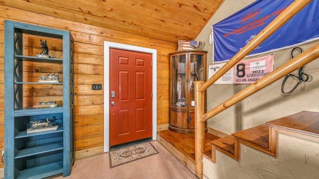 foyer featuring wood ceiling, wood walls, and lofted ceiling