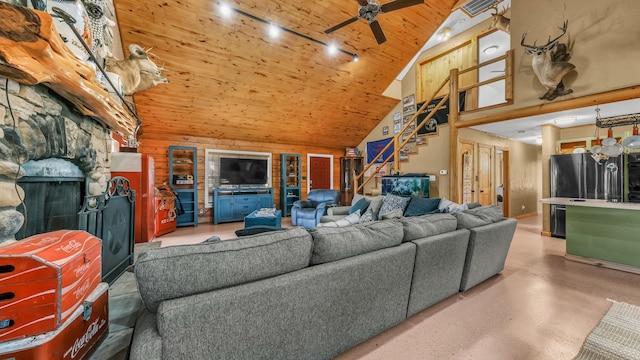 living room featuring ceiling fan, vaulted ceiling, wood ceiling, and wooden walls