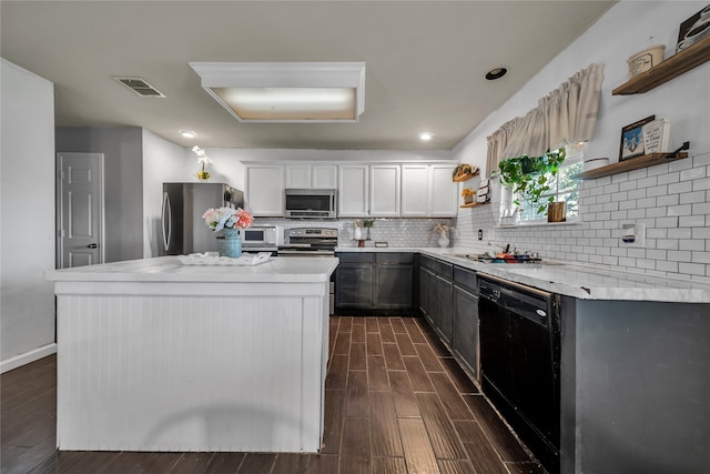 kitchen featuring dark wood-type flooring, stainless steel appliances, decorative backsplash, and white cabinets