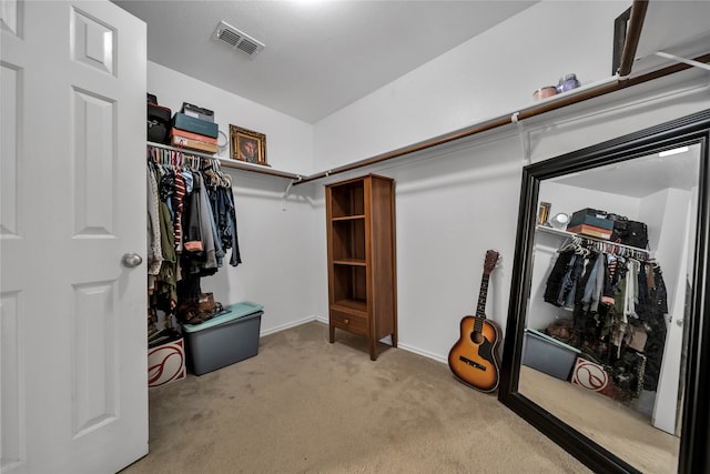 walk in closet with light carpet