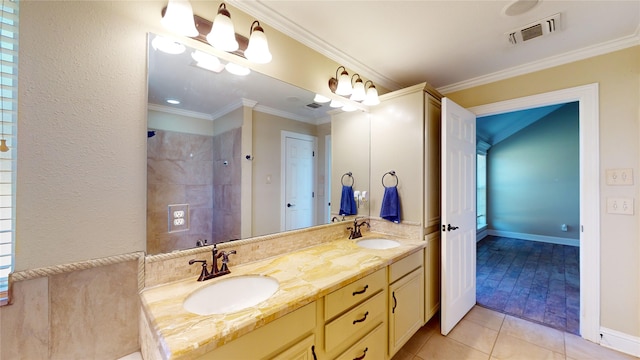 bathroom with vanity, ornamental molding, tiled shower, and tile patterned flooring