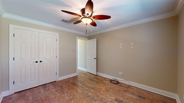 unfurnished bedroom with a closet, ceiling fan, crown molding, and wood-type flooring