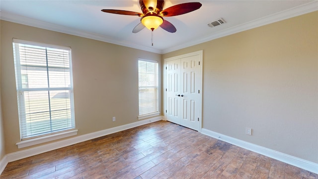 empty room with ceiling fan, wood-type flooring, and ornamental molding