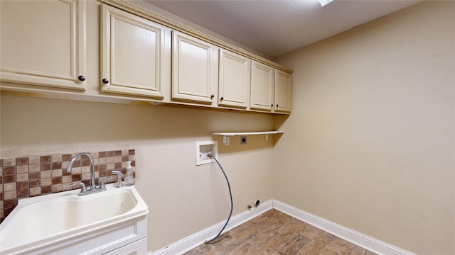 washroom with electric dryer hookup, washer hookup, sink, cabinets, and light hardwood / wood-style floors