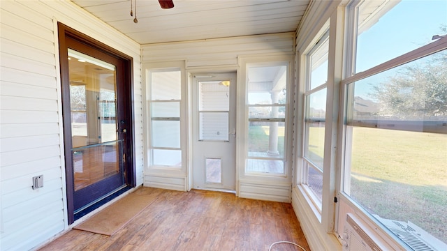 unfurnished sunroom with wood ceiling, a wealth of natural light, and ceiling fan