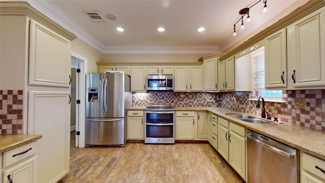 kitchen with cream cabinets, stainless steel appliances, and sink