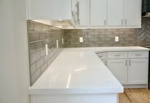 kitchen featuring white cabinetry, light wood-type flooring, and tasteful backsplash