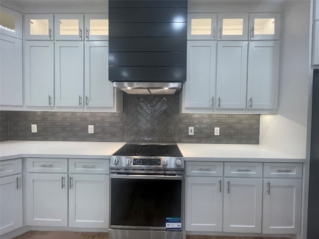 kitchen with white cabinetry, exhaust hood, backsplash, and electric stove