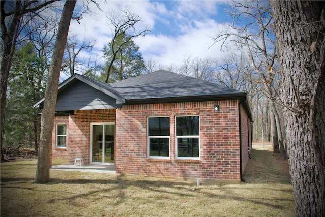 rear view of property featuring a patio area and a yard