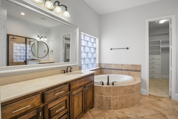 bathroom featuring vanity, tile patterned floors, and tiled bath