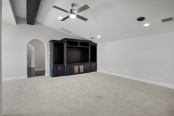 unfurnished living room with lofted ceiling with beams, carpet flooring, and ceiling fan