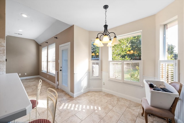 dining space with a notable chandelier, lofted ceiling, and plenty of natural light