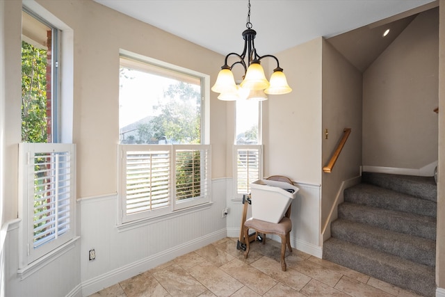 interior space featuring vaulted ceiling, a healthy amount of sunlight, an inviting chandelier, and tile patterned flooring