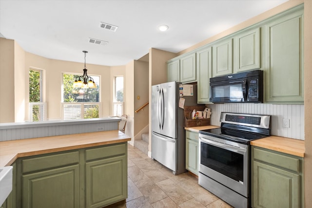 kitchen with a notable chandelier, wooden counters, stainless steel appliances, and green cabinetry