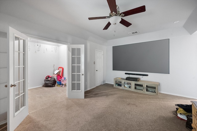 carpeted cinema room featuring french doors and ceiling fan