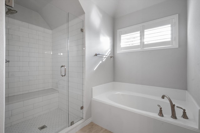 bathroom featuring lofted ceiling and separate shower and tub