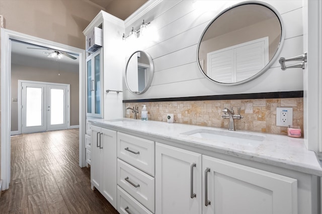 bathroom featuring wood-type flooring, french doors, ceiling fan, vanity, and decorative backsplash