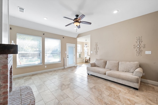 living room with ceiling fan with notable chandelier