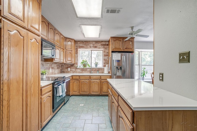 kitchen with decorative backsplash, a wealth of natural light, sink, and black appliances