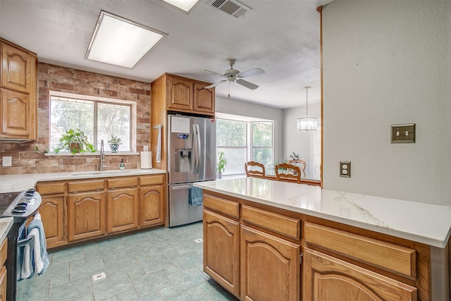 kitchen with pendant lighting, sink, stainless steel appliances, and a wealth of natural light