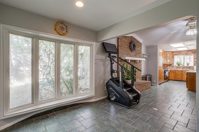 exercise room with ceiling fan, plenty of natural light, and vaulted ceiling