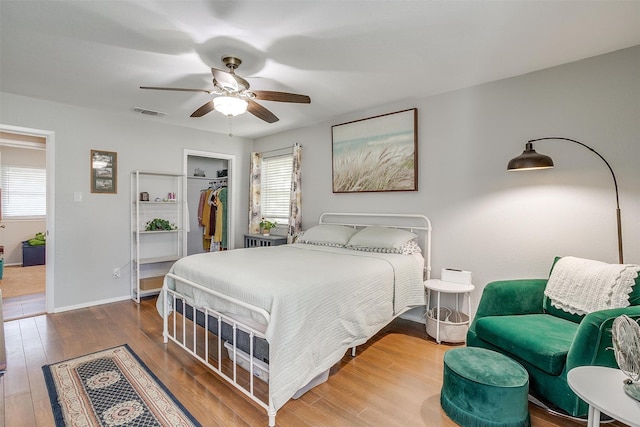 bedroom featuring wood-type flooring, a closet, a spacious closet, and ceiling fan