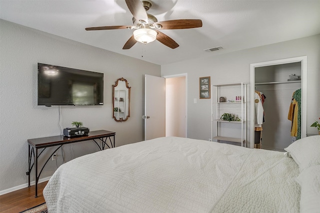 bedroom with ceiling fan, wood-type flooring, and a closet