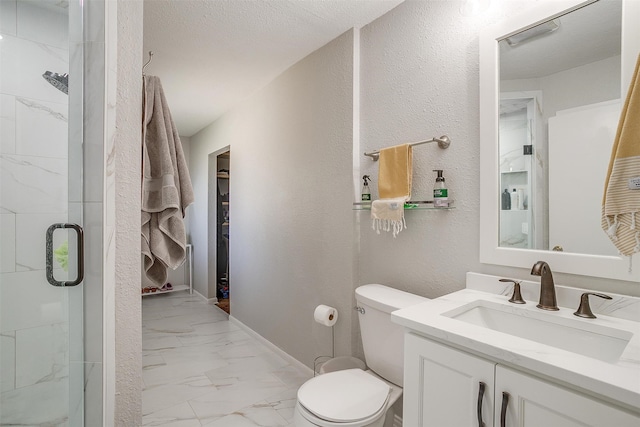 bathroom with vanity, a shower with shower door, a textured ceiling, and toilet