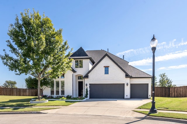 french provincial home with a front yard and a garage