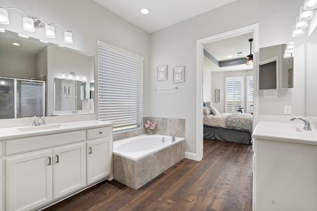 bathroom with vanity, independent shower and bath, hardwood / wood-style floors, and ceiling fan