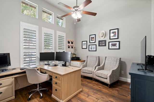 office area with dark hardwood / wood-style floors, a high ceiling, and ceiling fan