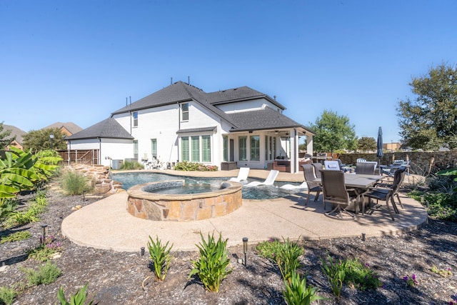 back of property with a patio area and a pool with hot tub