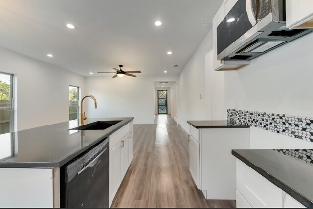 kitchen featuring white cabinetry, sink, stainless steel dishwasher, and a kitchen island with sink